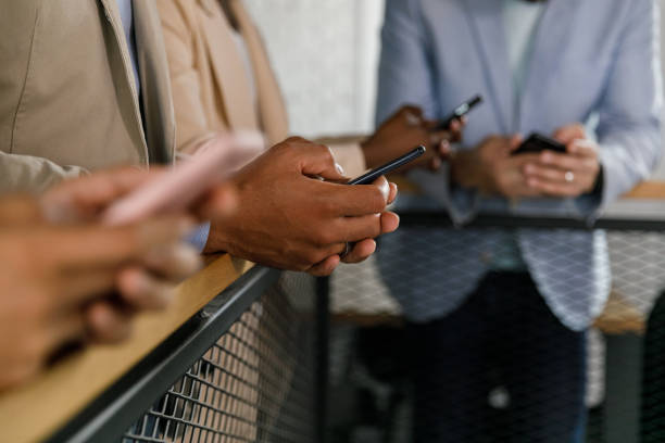 istock Four unrecognizable business people using smart phones 1390133917