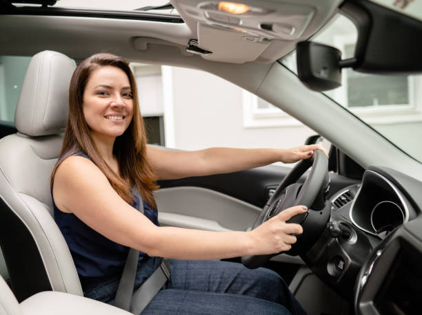 istock Woman smiling while sitting inside of an SUV before a drive 1390139522