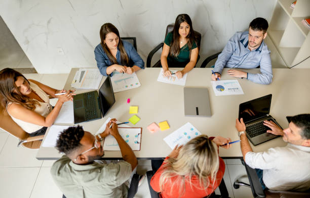 istock Businesspeople sitting around a boardroom table during a meeting 1390142394