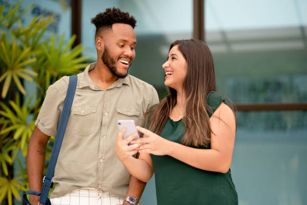 istock Diverse friends laughing at something on a cellphone outside a hotel 1390143388