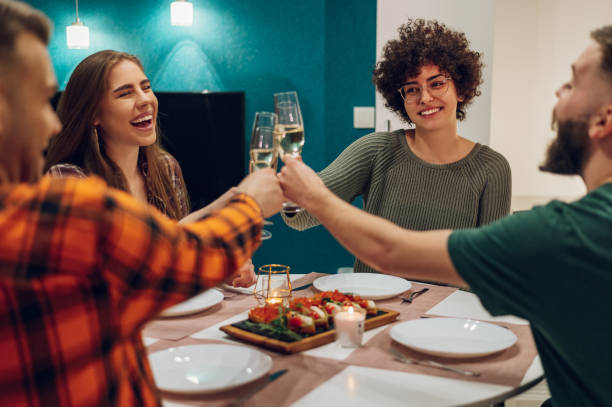 istock Friends sitting at a kitchen table and toasting during a dinner part 1390145965