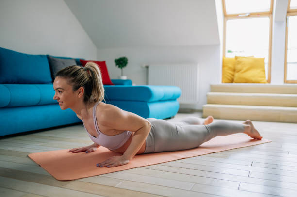 istock Woman practicing yoga at home and doing Double Leg Kicks pose. 1390145971