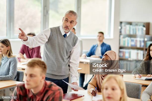 Mature Teacher Assisting Black Islamic Student During A Lecture In The Classroom Stock Photo - Download Image Now