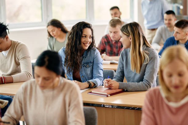 istock Happy female students talking during a class at university classroom. 1390147824