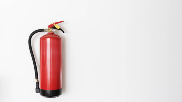 красный огнетушитель висит на белой стене - fire extinguisher office safety protection стоковые фото и изображения