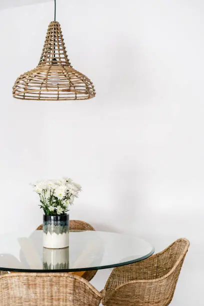 Photo of Wicker armchair near glass table in kitchen