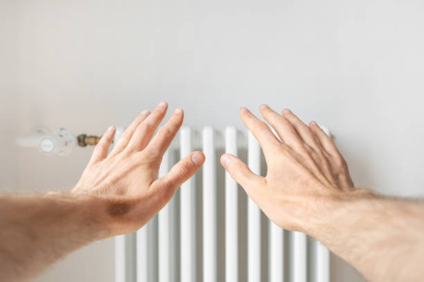 istock Man reach his hands to new heating radiator 1390148870