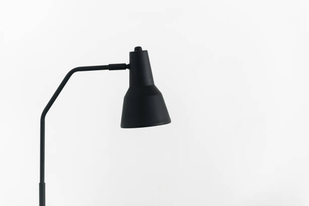 istock Black metal lamp standing against white cope space wall 1390148982