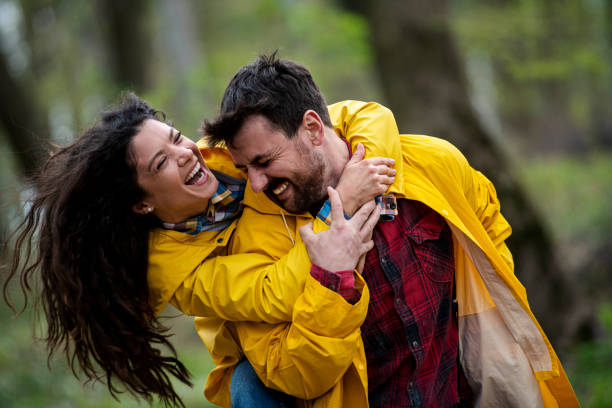 istock Happy affectionate couple in raincoats enjoying in nature 1390151123