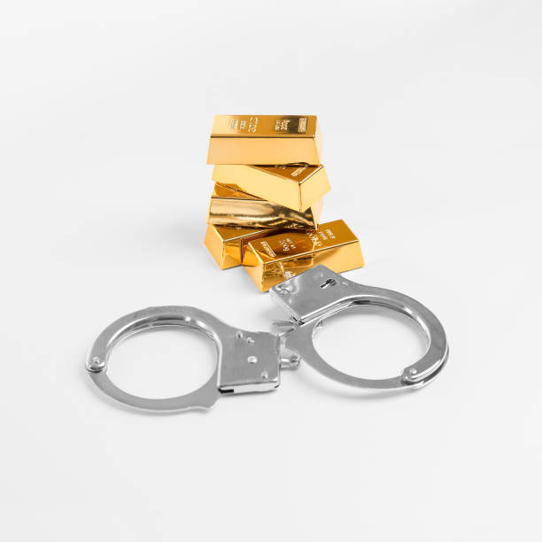 istock Handcuffs and gold bars on a white background 1390151339
