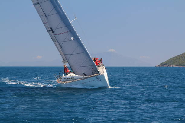 segelboote segeln bei windigem wetter im blauen wasser der ägäis - sailboat storm teamwork competition stock-fotos und bilder