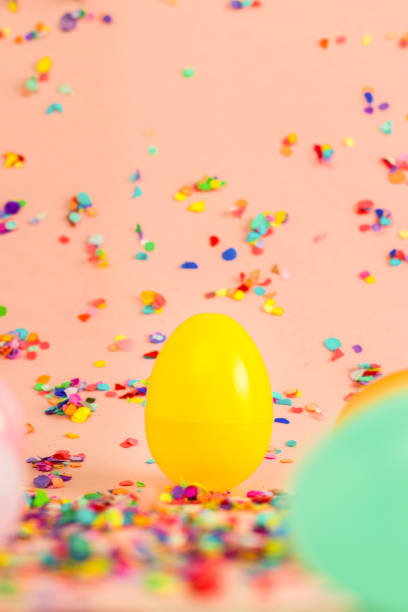 istock easter photo shoot with pink background and confetti, yellow central egg 1390154036