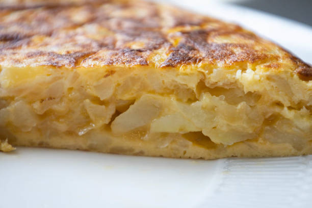istock Spanish omelette portion with potato and onion, in a white plate ready to eat 1390155011