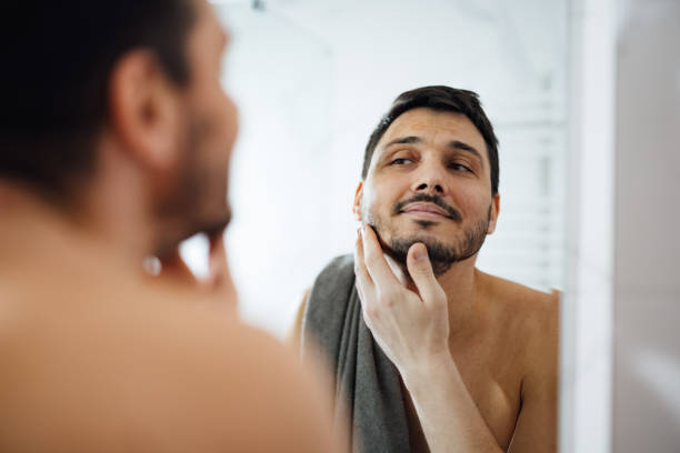 istock Handsome Man Checking his Appearance in a Bathroom Mirror 1390155861