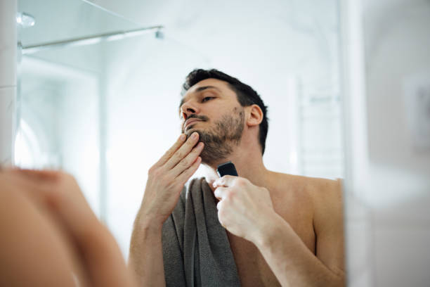 istock Handsome Man Shaving His Beard with an Electric Razor 1390155862