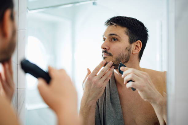 istock Handsome Man Shaving His Beard with an Electric Razor 1390155865