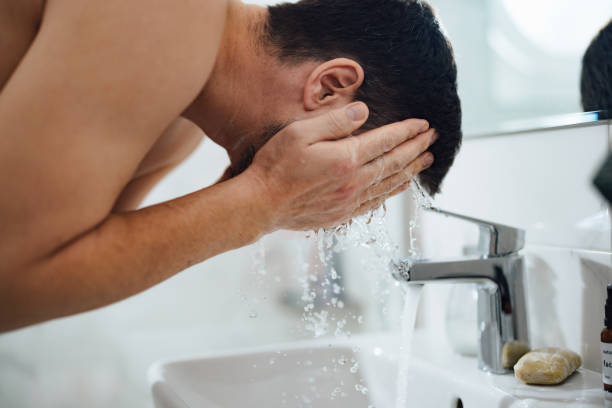 istock Unrecognizable Man Washing his Face in the Bathroom 1390155883