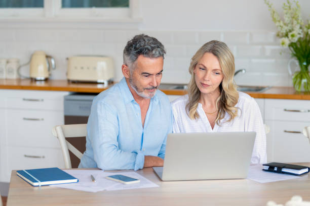 istock Mature couple doing paperwork and paying bills at home. 1390156785