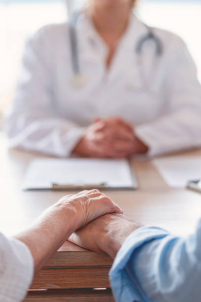 istock Mature couple holding hands at a doctors office. 1390156787