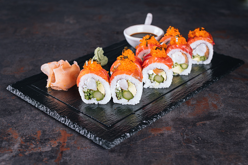 Set of tuna sushi rolls on black desk background.