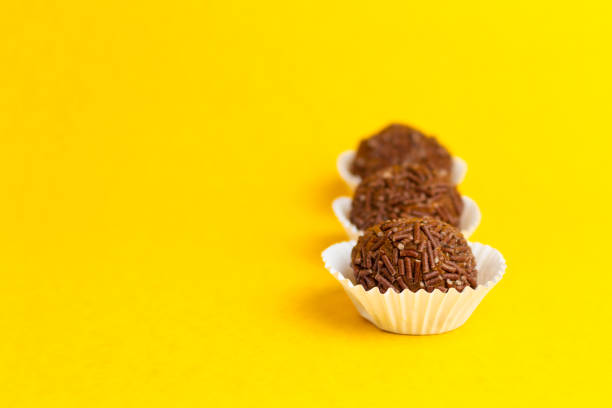 istock Brigadeiros lined up on a yellow background 1390159672