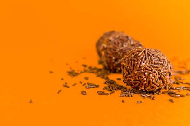 istock Brigadeiros lined up on a orange background 1390159805