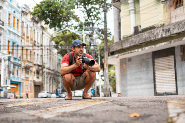 paparazzi photographer in the city - reportage photographer photographing street imagens e fotografias de stock