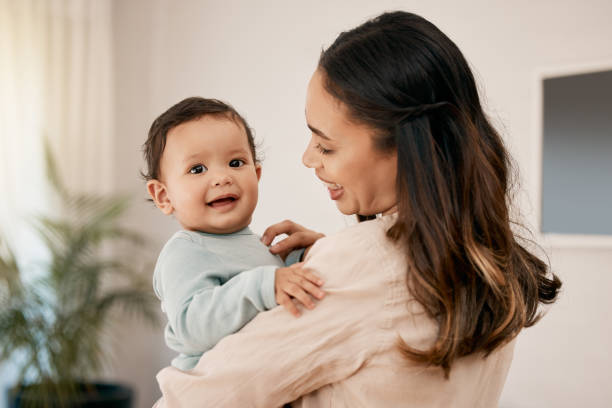 foto de una joven madre que se une a su adorable bebé en casa - baby cute selective focus close up fotografías e imágenes de stock