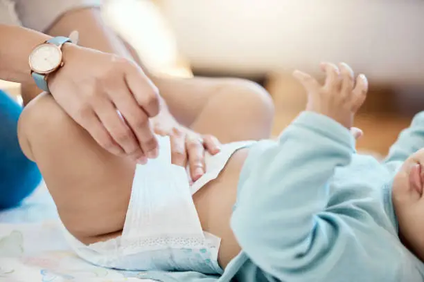 Photo of Cropped shot of a woman changing a baby's diaper