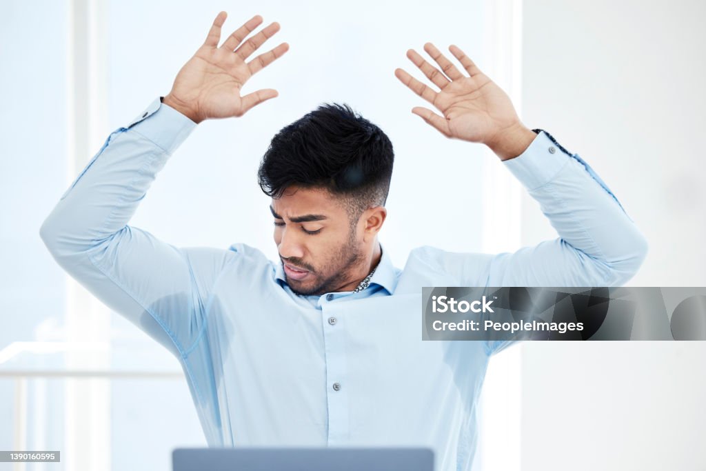 Shot of a young businessman with sweat stained through the underarms of his shirt All sweaty and stressed Sweat Stock Photo