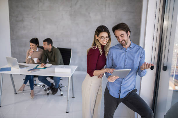 istock Happy business colleagues using a digital tablet and cooperating in office. 1390160656