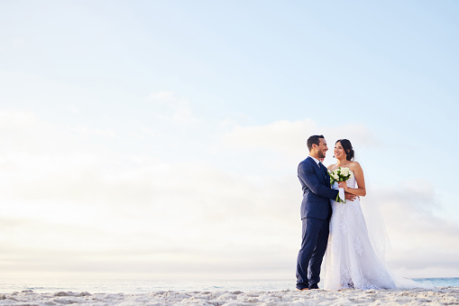 Foto de una joven pareja en la playa el día de su boda photo