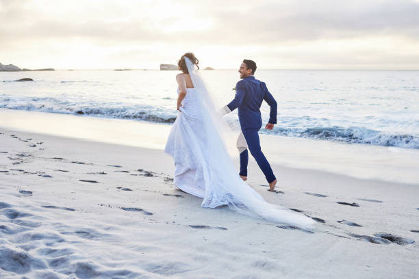 photo d’un jeune couple sur la plage le jour de leur mariage - elope photos et images de collection