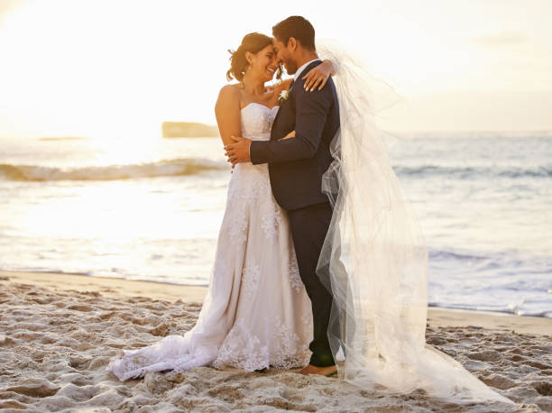 scatto di una giovane coppia sulla spiaggia il giorno del loro matrimonio - wedding beach bride groom foto e immagini stock