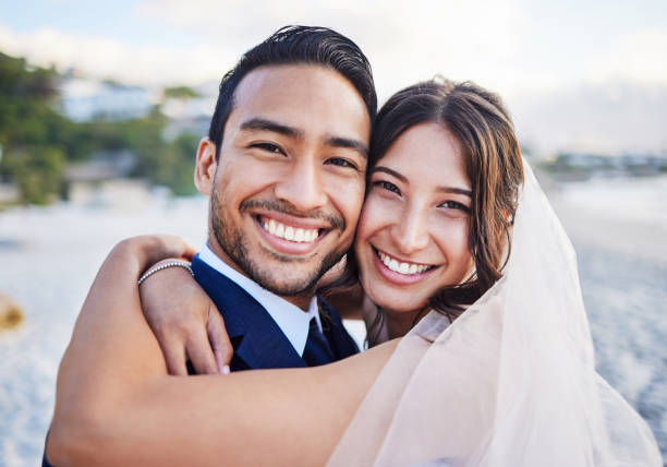 scatto di una giovane coppia sulla spiaggia il giorno del loro matrimonio - newlywed foto e immagini stock