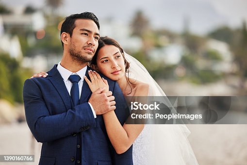 istock Shot of a young couple on the beach on their wedding day 1390160766