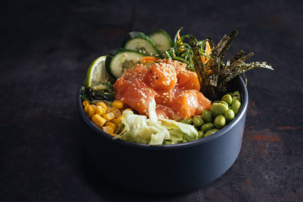 istock Poke bowl with salmon, avocado and vegetables on light background overhead view 1390161545