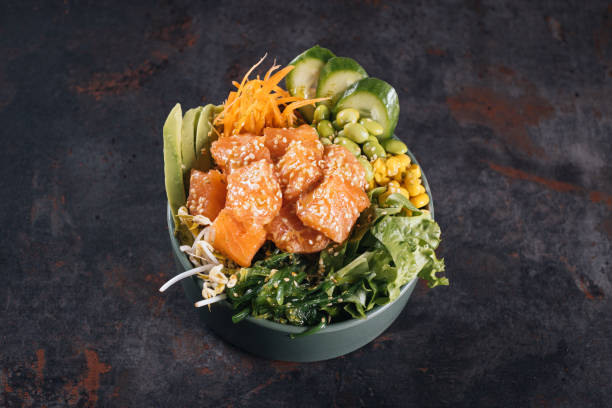 istock Poke bowl with salmon, avocado and vegetables on light background overhead view 1390161630