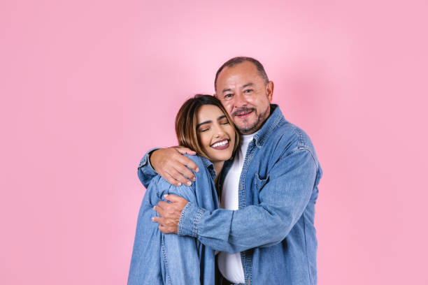 pai e filha latinas em roupas casuais em um espaço de cópia em fundo rosa no méxico américa latina - senior adult family cheerful couple - fotografias e filmes do acervo