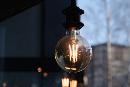 Closeup of a modern vintage-like Edison lamp hanging in the cafeteria