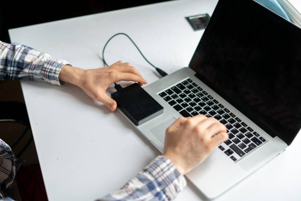 istock holding backup external hdd with archive and connect it to the laptop 1390174440