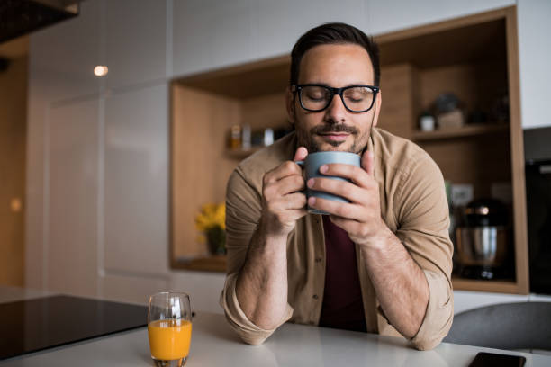 Young man drinking his morning coffee at home. stock photo