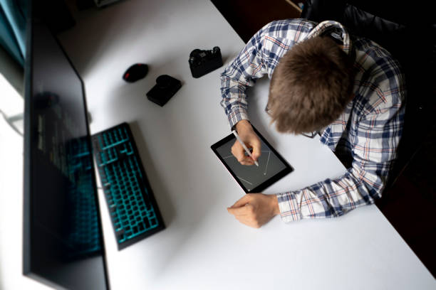 male graphic designer working using stiylus and tablet in the studio