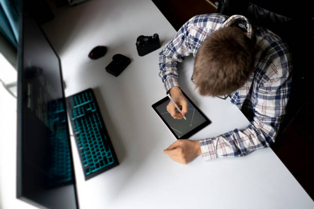 male graphic designer working using stiylus and tablet in the studio stock photo