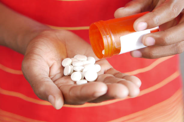 istock man's hand with medicine spilled out of the pill container 1390188263