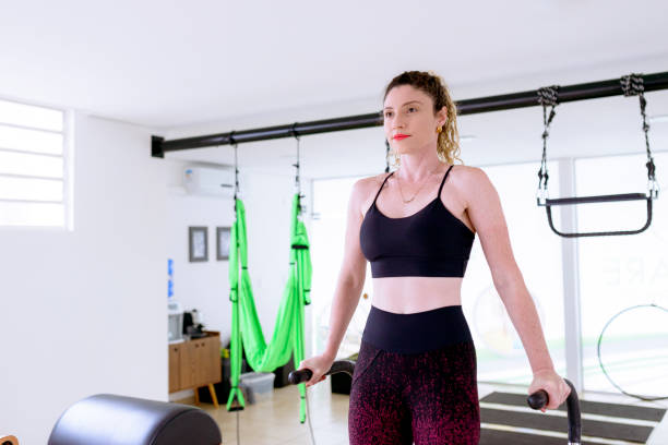 istock Woman with curly hair doing pilates on a machine 1390190034