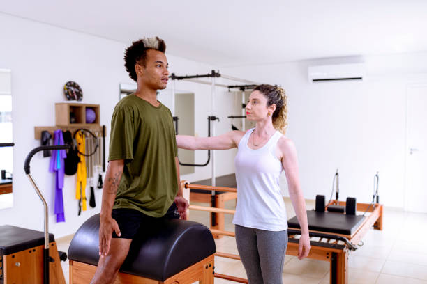 istock Instructor showing movement to student in pilates apparatus 1390190221