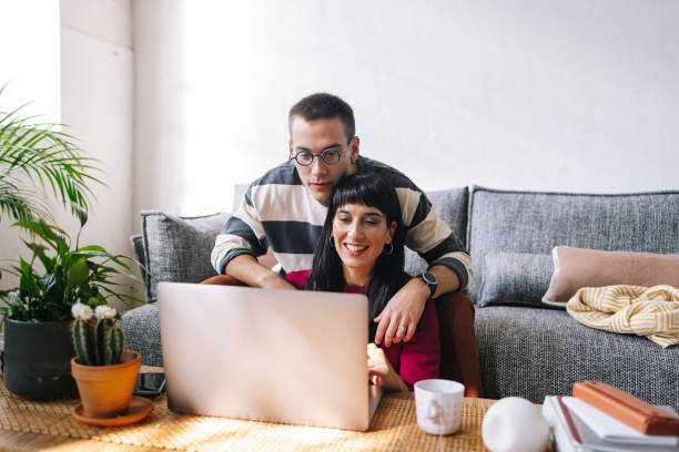 istock An Enthusiastic Couple Smiling While Working Together From Home Using Their Laptop 1390191740