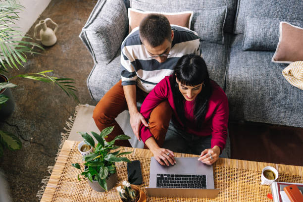 istock A From Above Shot Of A Lovely Couple Smiling While Working Together From Home Using Their Laptop 1390191754