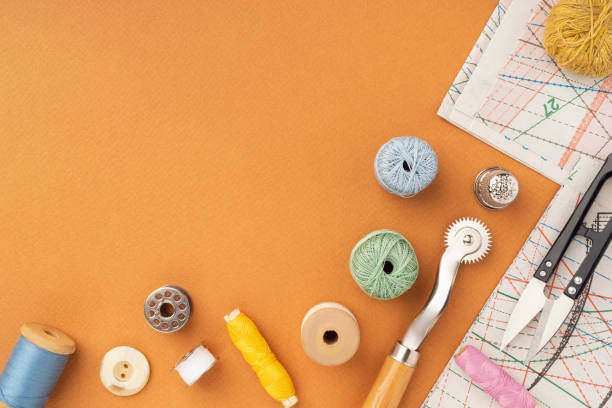 istock Pattern, fabric and sewing accessories on a bright orange paper background, flat, lay, top view, copy space. A tailor or seamstress desk. Sewing concept, background. Tailoring of designer clothes 1390193427